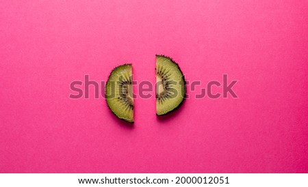 Two pieces of kiwi on pink background