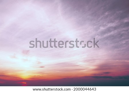 A view of the sky at sunset in vibrant orange pinks and violet colors