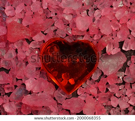 the figure of a red heart on a background of pink small stones