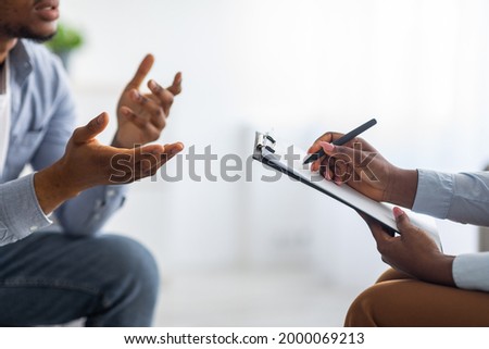 Professional psychological help concept. Unrecognizable black man talking to psychotherapist at office, closeup view. Depressed male patient having consultation with counsellor Royalty-Free Stock Photo #2000069213