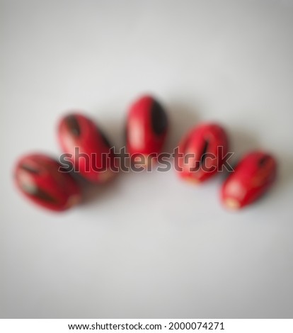 defocused abstract backround of Nutmeg seeds and red skin