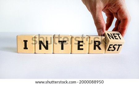 Internet and interest symbol. Businessman turns wooden cubes and changes the words interest to internet. Beautiful white background. Copy space. Business, internet and interest concept.