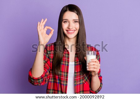 Photo of cool brunette hairdo millennial lady show okey drink milk wear red shirt isolated on purple color background