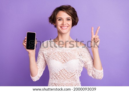 Portrait of attractive friendly lady demonstrate display fingers show v-sign isolated on purple color background