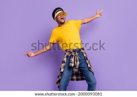 Portrait of attractive cool cheerful guy wearing sun hat clubbing dancing isolated over violet purple color background