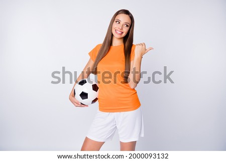 Photo of captain soccer team joyful lady direct thumb finger empty space euro cup 2020 league bets hold ball wear national team football uniform t-shirt shorts isolated white color background Royalty-Free Stock Photo #2000093132