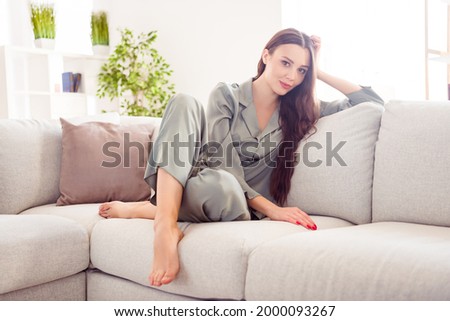 Full length photo of young attractive girl happy positive smile sitting couch living-room wear nightwear home