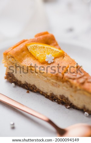 Festive orange cheesecake slice. Serving of traditional Polish cake on Christmas table.