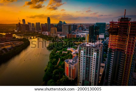 condos and apartments with the best views of a Perfect Austin Texas Sunset from aerial drone view over Amazing Golden Hour Views of Skyline Cityscape and curved Colorado River or Lady Bird Lake
