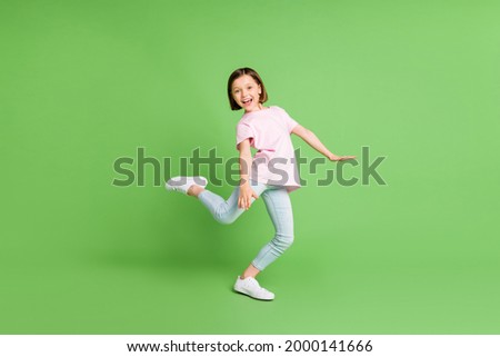 Full body profile side photo of young excited girl happy positive smile enjoy music dance isolated over green color background