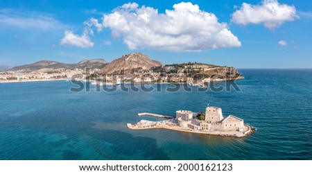 Greece, Nafplio city and Bourtzi, Venetian water fortress at the entrance of the harbour. Aerial drone view. Peloponnese old town cityscape, Blue sky with clouds, calm sea background.