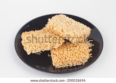 A block of dried Instant noodles on dish with gray background