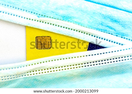 a credit card peeks out from behind medical hygiene masks concept business and coronavirus. High quality photo