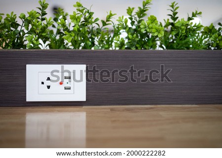 Electric power outlet socket with built in USB chargers on the table between seats for charging students' mobile phones or plugging in electrical appliances in restaurant or dining room at school Royalty-Free Stock Photo #2000222282