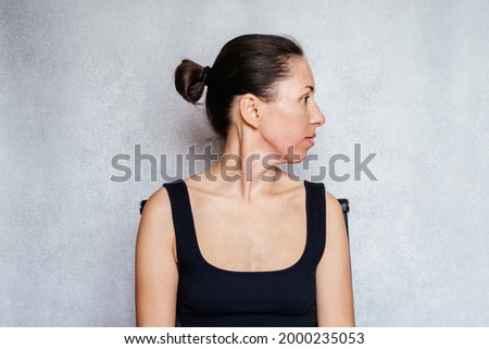 McKenzie method exercise to relieve neck pain, a woman gently rotates her head while doing neck pain relief exercises Royalty-Free Stock Photo #2000235053