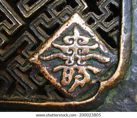 Bronze hieroglyph SHOU (longevity, long innings) on the fence of monastery, China