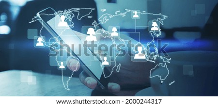 Close up of hands at desktop using cellphone with glowing map and people icons. Social media and online recruiting concept. Double exposure