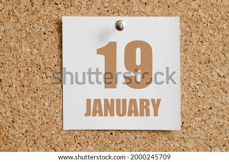 january 19. 19th day of the month, calendar date.White calendar sheet attached to brown cork board. Winter month, day of the year concept.