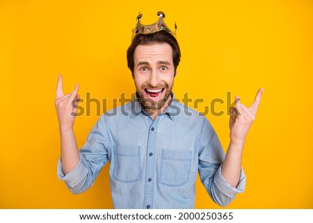 Photo of young excited man happy positive smile show rock sign crown king isolated over yellow color background