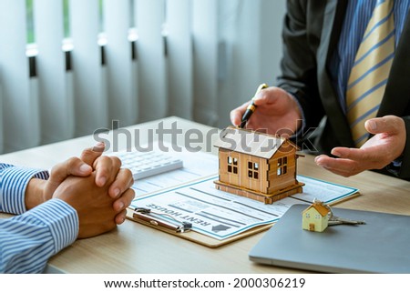 Real estate broker agent, concerning mortgage loan offer for and house insurance presenting and consult to the customer to decision making sign insurance form agreement, home model, 