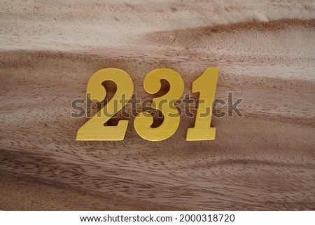 Gold Arabic numerals 231 on a dark brown to off-white wood pattern background.