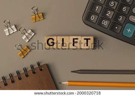 Word - GIFT - on small wooden blocks on the desk. Conceptual photo. Top view