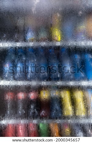 Vending machine. Soft drinks behind a glass covered with water drops.