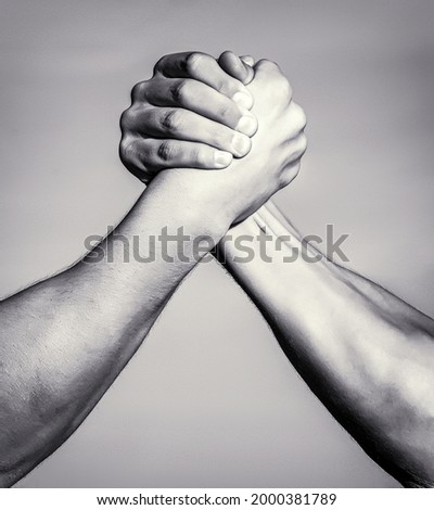 Two men arm wrestling. Arms wrestling. Closep up. Friendly handshake, friends greeting, teamwork, friendship. Handshake, arms friendship Black and white