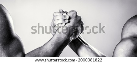 Rivalry, closeup of male arm wrestling. Two hands. Men measuring forces, arms. Hand wrestling, compete. Black and white.