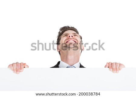 Portrait of confident businessman showing billboard over white background