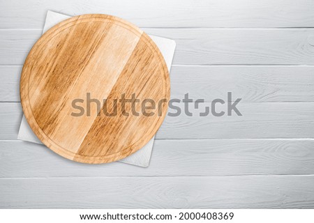 Empty pizza board on a wooden deck