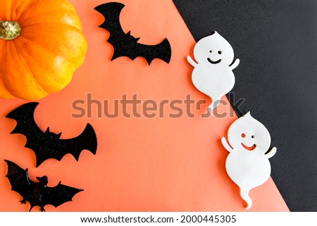 Happy Halloween decoration. Pumpkin, ghost and bats on orange background.