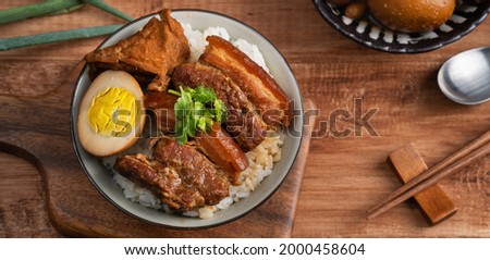 Braised pork belly, close up of stewed pork chop over cooked rice in Taiwan. Taiwanese famous traditional street food delicacy. Royalty-Free Stock Photo #2000458604