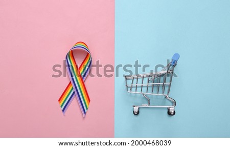 LGBT rainbow ribbon pride tape symbol and shopping trolley on pink blue pastel background.