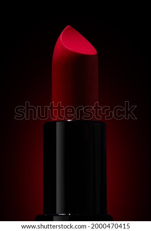 still life of red lipstick on black background