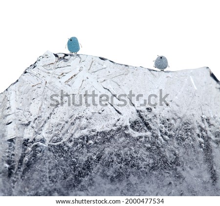 funny little penguins made of a piece of seaglass, with sketchily drawn legs and beak, on a mountain of ice, isolated on white background
