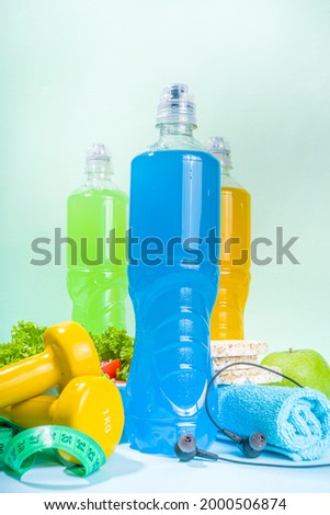 Sport healthy lifestyle, diet concept. Slimming weight loss fitness background with measuring tape, colored dumbbells, salad, cereal crisp bread, sports water bottle on Blue background copy space  