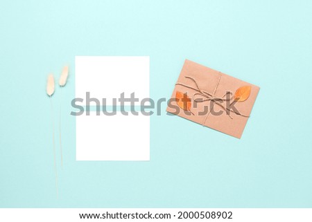 Blank business cards mockup, letter, autumn leaves and dry grass on pastel mint blue paper background. Autumn stationery still life. Top view, flat lay