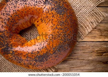 Freshly baked bread with poppy seeds on a wooden background.