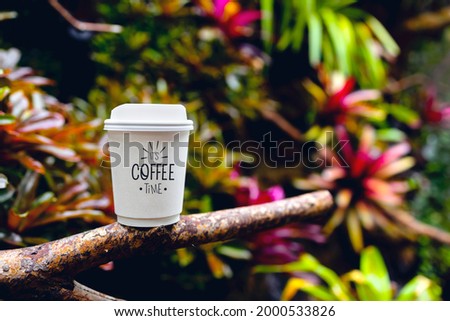 white paper cup of coffee in the beautiful nature with soft focus and over light in the background. mockup and templates to create greeting, cards, magazines, cover, poster and banners. 