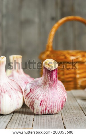 garlic bulbs and basket on rustic wooden table