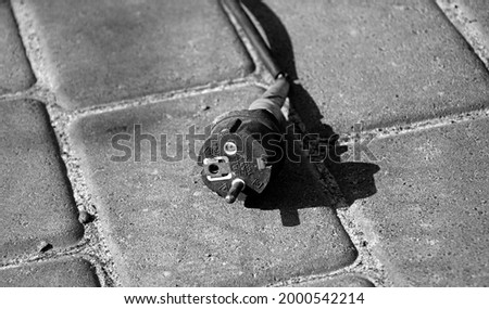Defective electrical cable lying on the pavement