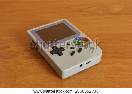 High resolution photo of a gray retro video game console with colored buttons and lcd screen. Royalty-Free Stock Photo #2000552936