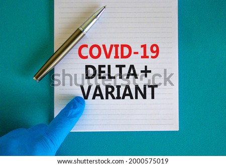 Covid-19 delta plus variant strain symbol. Hand in blue glove with white card. Concept words Covid-19 delta plus variant. Metalic pen. Medical, COVID-19 delta plus variant strain concept. Copy space.