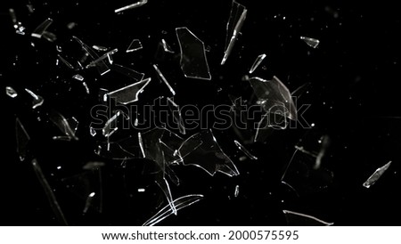 Studio full-frame wide plate shot of window glass pane shattering and breaking on black background. Real smash explosion at high speed as action concept template and overlay element. Royalty-Free Stock Photo #2000575595