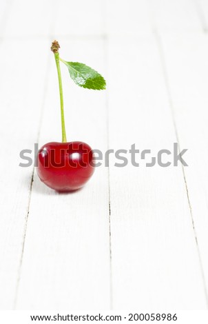 sour cherry with leaf on white wooden table