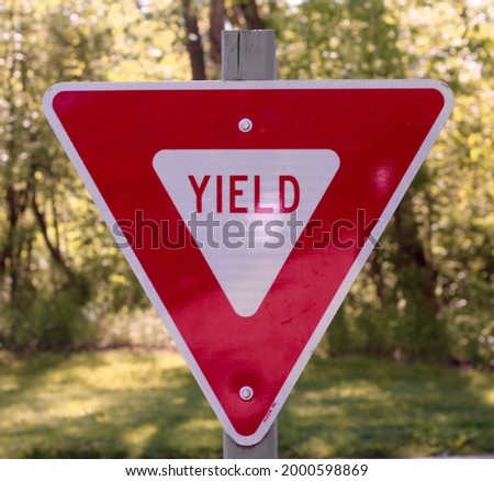 A close view on the red and white yield sign.
