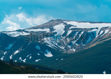summer mountains in snow on a cloudy day