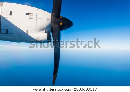 See the view of the aircraft engine and the blue sky from the window during flight