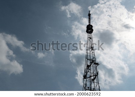 silhouette TV signal transmission and communication towers against the background of a cloudy sky